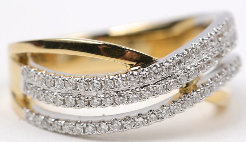 Een 18 karaats wit en geel gouden ring bezet met briljanten met een gezamenlijk gewicht van ± 0,46 ct.