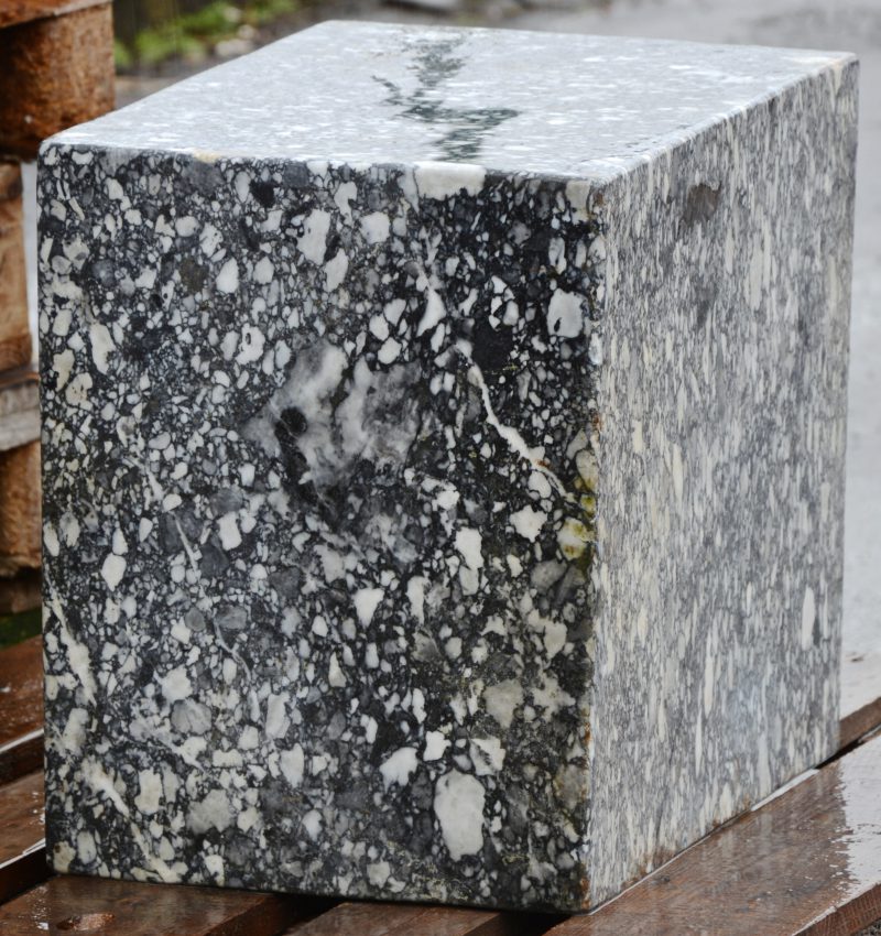 Een kubus van grijs marmer.