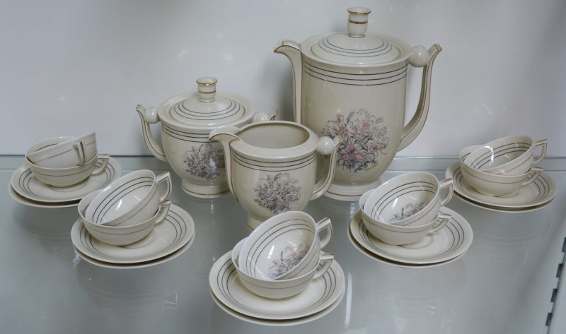 Een theeserviesje, bestaande uit een theepot, melkkan, suikerpot en tien kopjes met ondertasjes. Onderaan gemerkt.