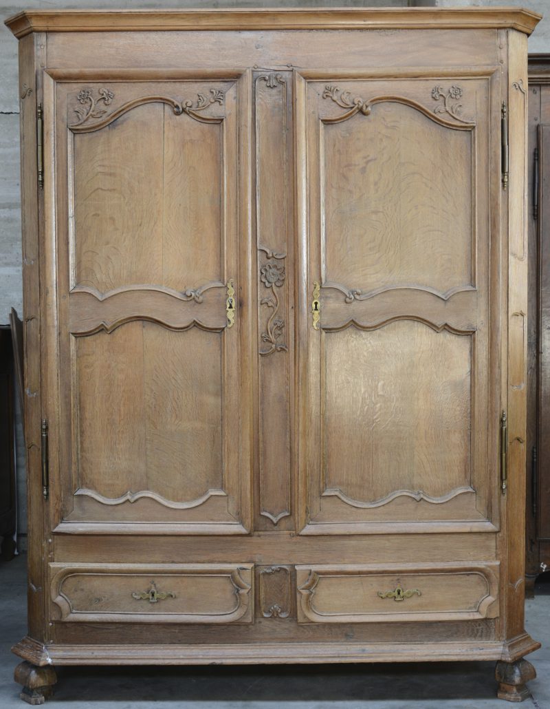 Een bleek eikenhouten garderobe in Lodewijk XV-stijl met twee deuren en twee laden. Eind XVIIIe eeuw.