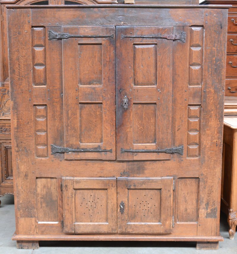 Een eikenhouten meubele met twee maal twee deuren, versierd met cassettes in Spaanse stijl. Als basis vroeg XVIIIe eeuws.