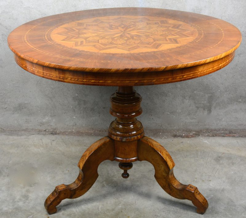Een over het geheel gemarquetteerde tafel op centrale poot, het blad versierd met geometrisch stermotief. XIXe eeuw.