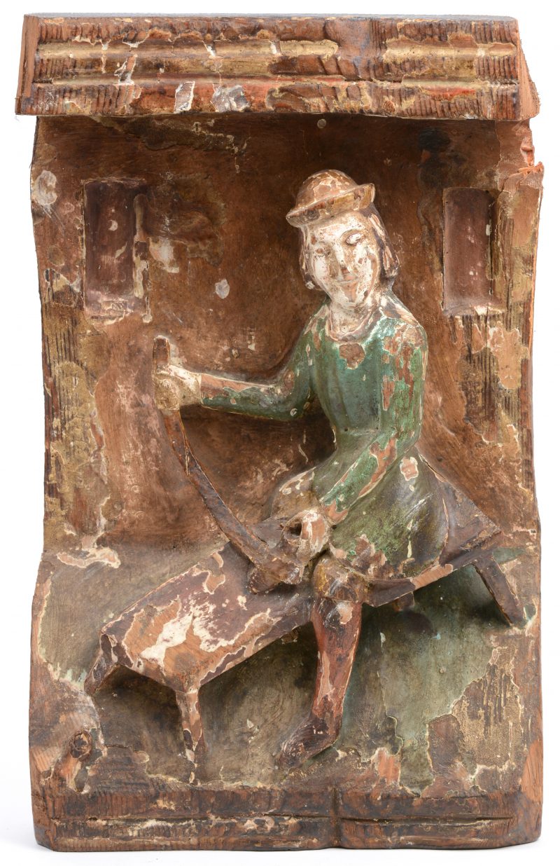 Een antiek gepolychromeerd houtsnijwerk met een voorstelling van een schoenmaker. Elzas.