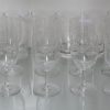 Een kleurloos kristallen glasservies met geslepen motieven. 12 wijnglazen en 10 waterglazen