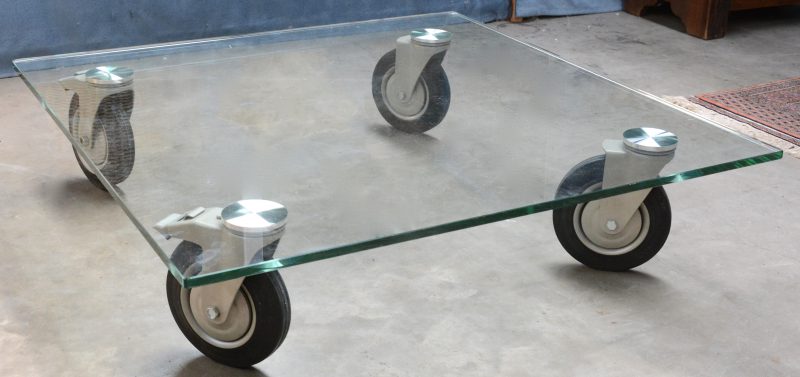 Een design salontafel met glazen blad op wielen naar ontwerp van Gae Aulenti voor Fontana Arte. Jaren ‘80.