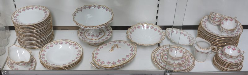 Een eetservies van Limogesporselein met een rozendecor met vergulde rocaillerand. Patent Porcelaine-Mousseline. Onderaan gemerkt.