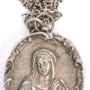 Een zilveren reliekhanger met een gedreven beeltenis van de Heilige Maagd met binnenin een waszegel en drie relikwieën.