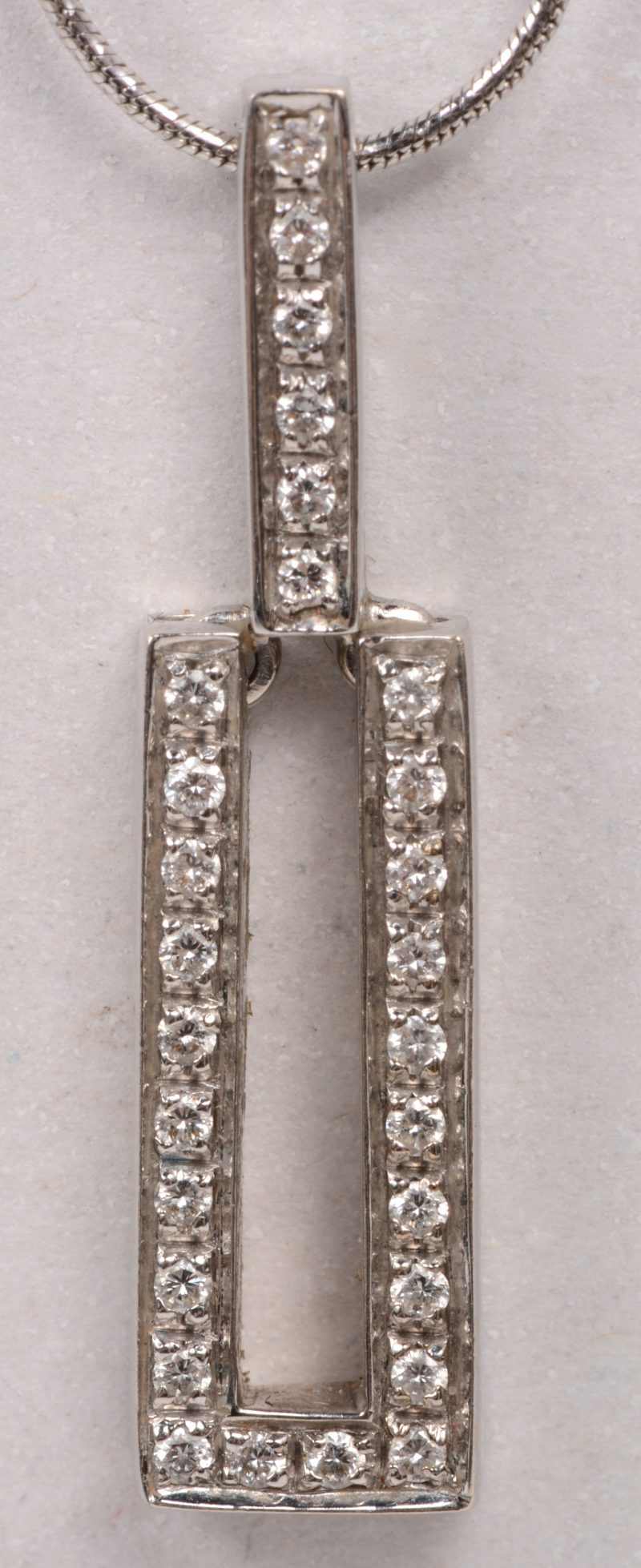 Een 18 karaats wit gouden ketting met hanger bezet met briljanten met een gezamenlijk gewicht van +/- 0,42 ct.