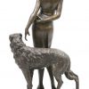 “Dame met hond”. Een bronzen groep op zwart marmeren sokkel. Gesigneerd.