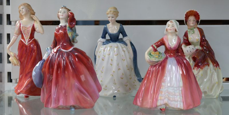 Een lot van vijf meerkleurig porseleinen beeldjes van dames in jurk. Gemerkt.
