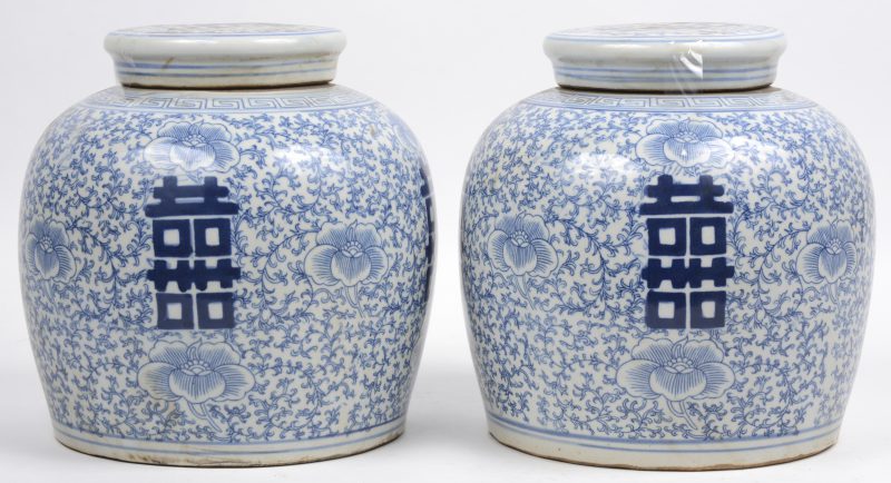 Een paar gemberpotten van Chinees porselein met een blauw op wit decor van bloemen en langlevenstekens.