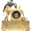 Een vuurvergulde bronzen schouwpendule met een allegorisch bas-reliëf op de koopvaardij in de basis. Bovenaan een tafereel van een pijprokende Moriaan bij een scheepsvracht met anker. Gemerkt op de wijzerplaat. XIXe eeuw.