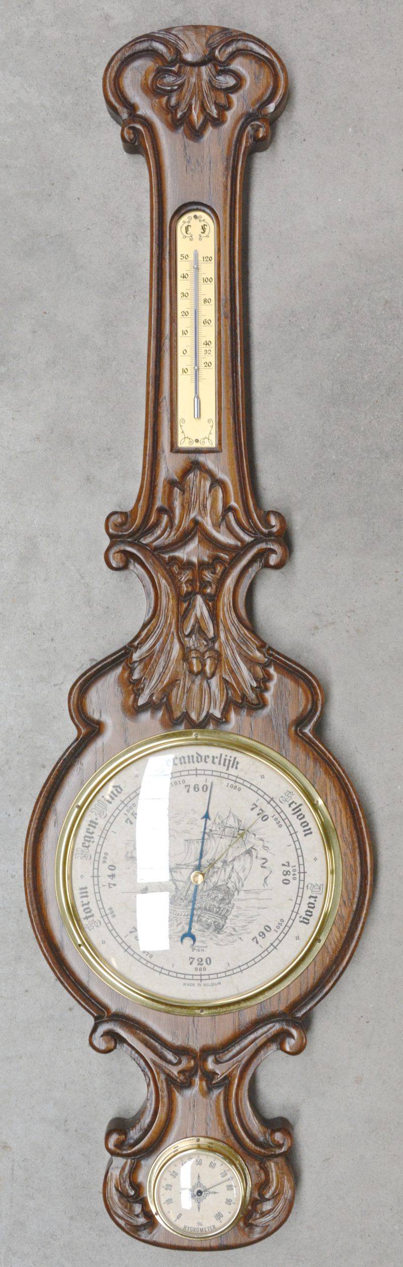 Een barometer in houten kast.