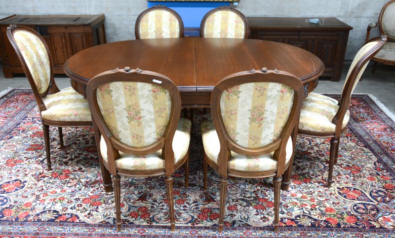 Een verlengbare tafel met zes bijpassende stoelen in Lodewijk XVI-stijl.