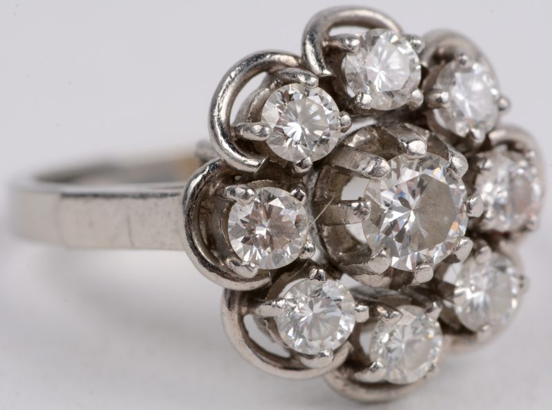 Een platina bloemvormige ring bezet met diamanten met een gezamenlijk gewicht van ± 1,10 ct .