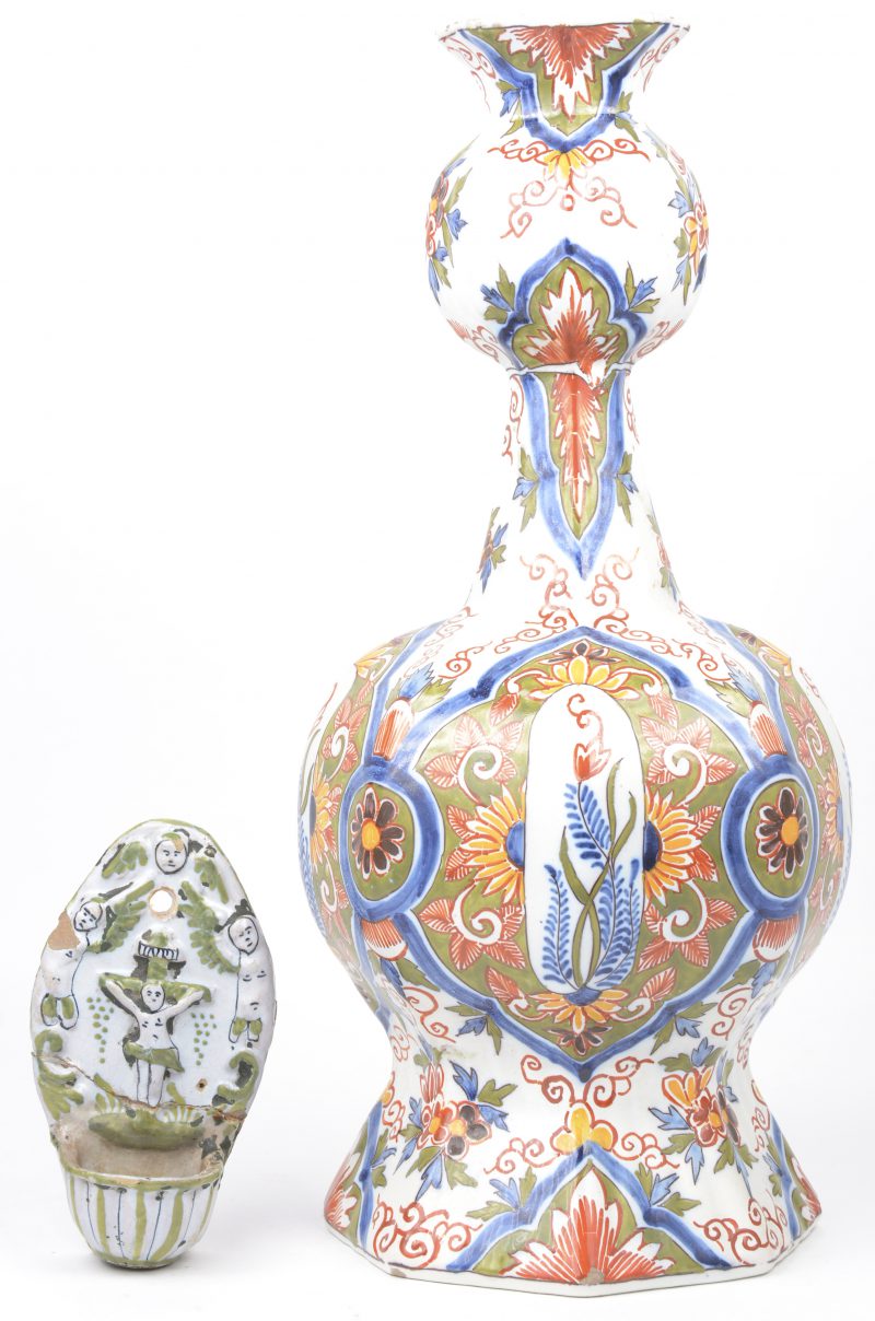 Een knobbelvaas en een wijwatervaatje van meerkleurig Delfts aardewerk. Beide gerestaureerd. XIXe eeuw.
