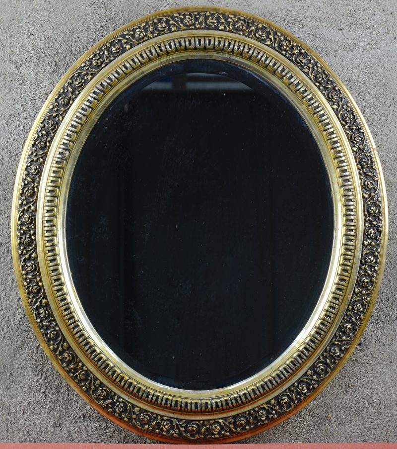 Een ovale verguld houten spiegel.