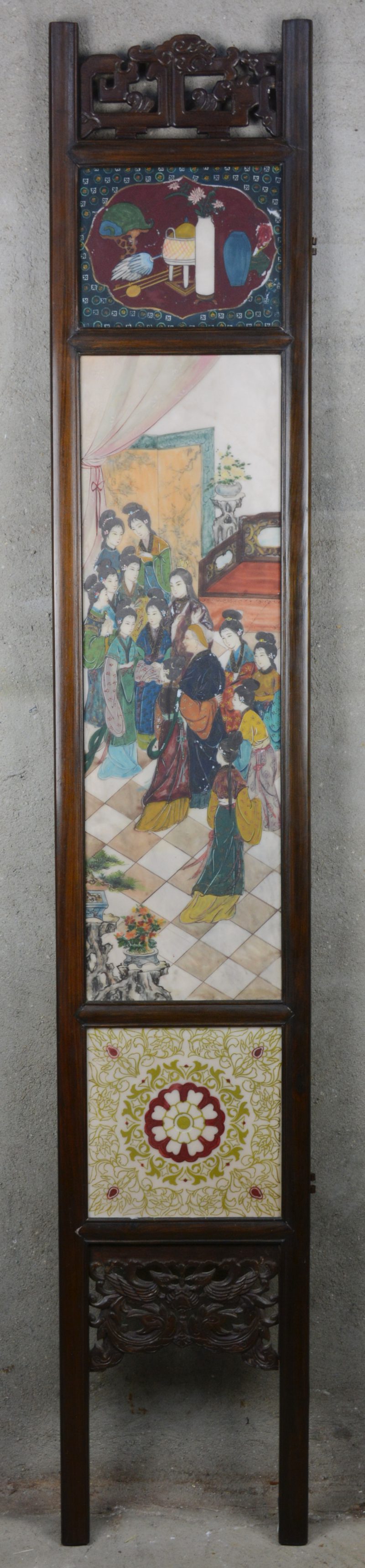 Een Chinees paneel met drie porseleinen plaquettes met personages, landschappen en tekens in een houten frame.