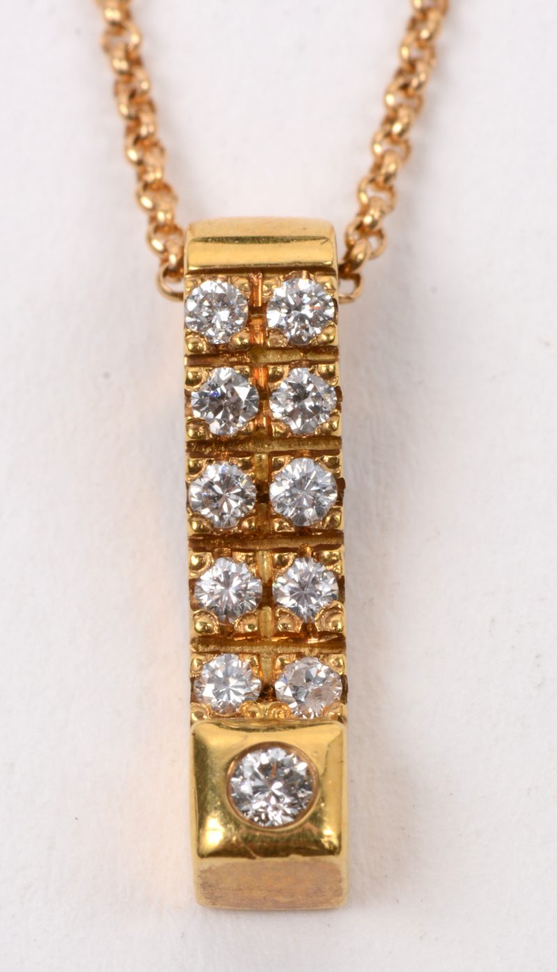 Een 18 karaats geel gouden ketting met hanger bezet met briljanten met een gezamenlijk gewicht van +- 0,22 ct.