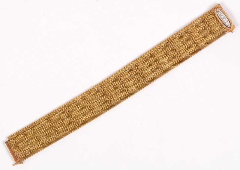 Een 18 karaats geel gouden geweven armband bezet met briljanten met een gezamenlijk gewicht van +- 0,20 ct.