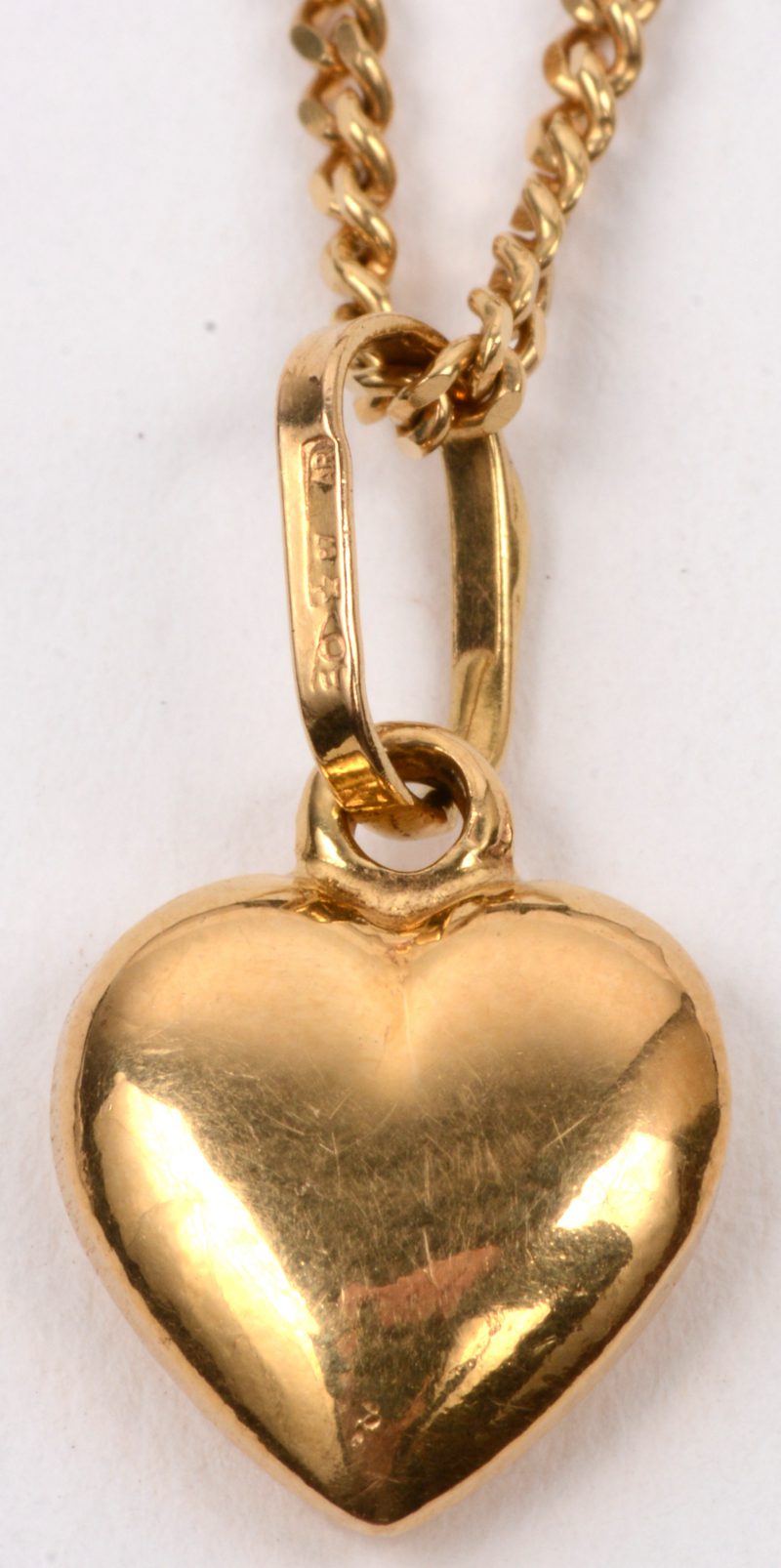 Een 18 karaats geel gouden schakelketting met een hartvormige hanger.