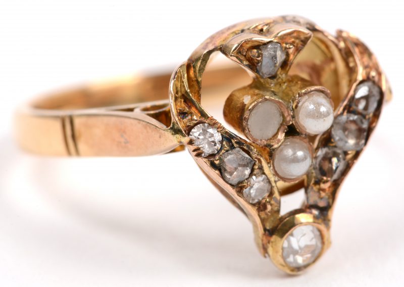 Een 18 karaats geel gouden ring bezet met diamanten oude slijp met een gezamenlijk gewicht van +- 0,30 ct. en pareltjes.