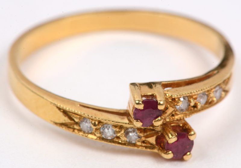 Een 18 karaats geel gouden ring bezet met zes briljantjes en twee robijntjes met een gezamenlijk gewicht van +- 0,14 ct.