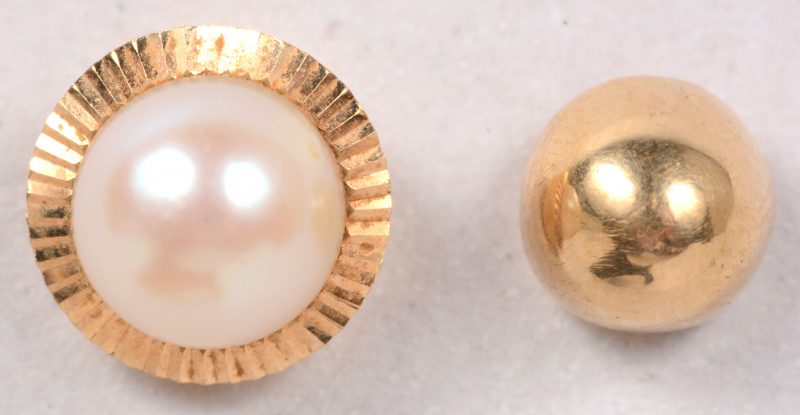 Twee verschillende 18 karaats geel gouden oorbellen één bezet met een bolletje en één bezet met een parel.