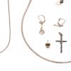 Een lotje zilver waaronder twee paar oorbellen, twee kettingen waarvan één met hanger, een kruisje en een speld.