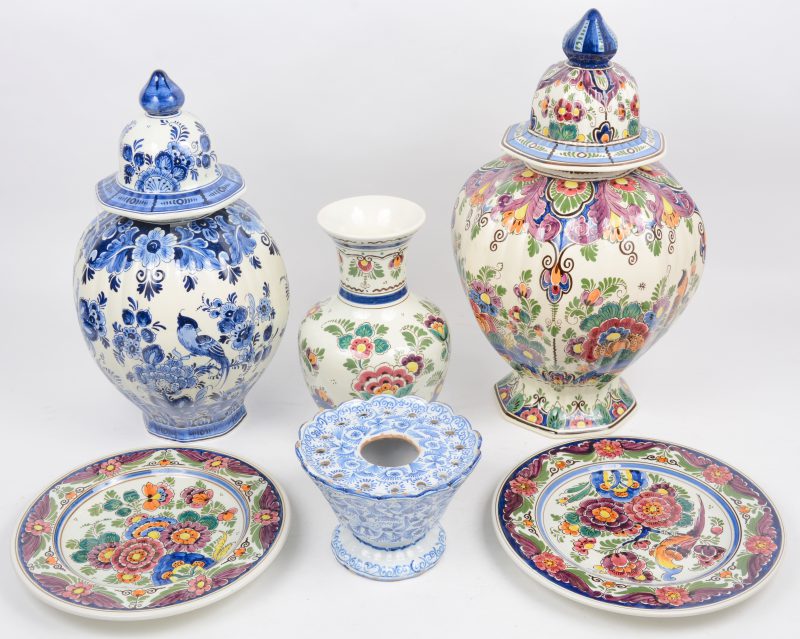 Een lot Delfts aardewerk, bestaande uit twee sierbordjes, een vaasje, een pique-fleurs en twee dekselvazen.