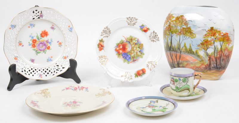 Een lot meerkleurig porselein , bestaande uit drie bordjes, een vaas met handgeschilderd decor en een Chinees kopje met twee ondertasjes.
