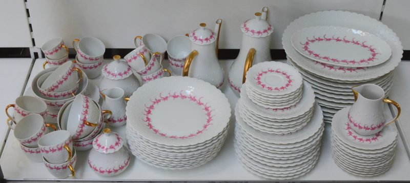 Een uitgebreid porseleinen servies versierd met roze bloemenguirlandes met onder meer een koffie- en theestel. Onderaan gemerkt.