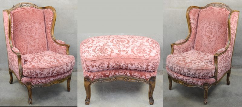 Een paar notenhouten fauteuils in Régencestijl met bijpassend voetbankje met roze bekleding.