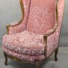 Een paar notenhouten fauteuils in Régencestijl met bijpassend voetbankje met roze bekleding.