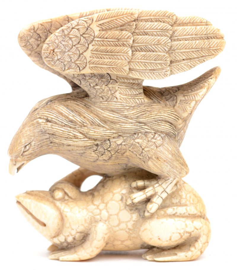 Een grote gesculpteerde ivoren netsuke in de vorm van een adelaar op een pad. Gesigneerd onderaan.