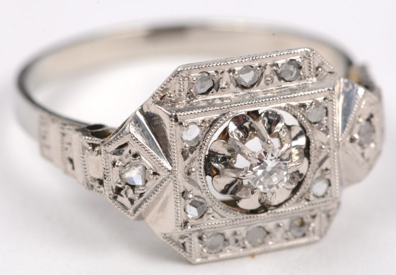 Een 18 karaats wit gouden ring bezet met diamanten oude slijp en één briljant met een gezamenlijk gewicht van +- 0,15 ct.