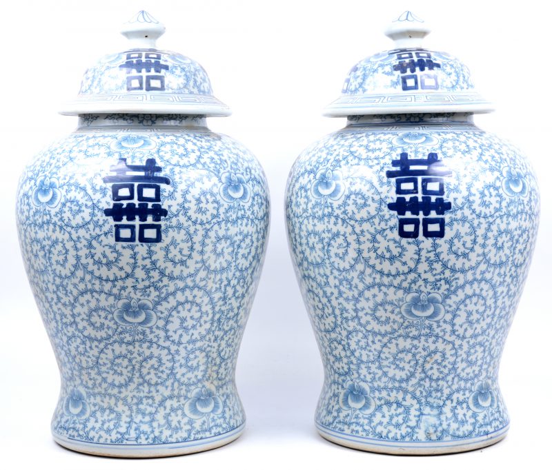 Een paar dekselvazen van Chinees porselein met een blauw op wit decor floraal decor met gelukstekens.