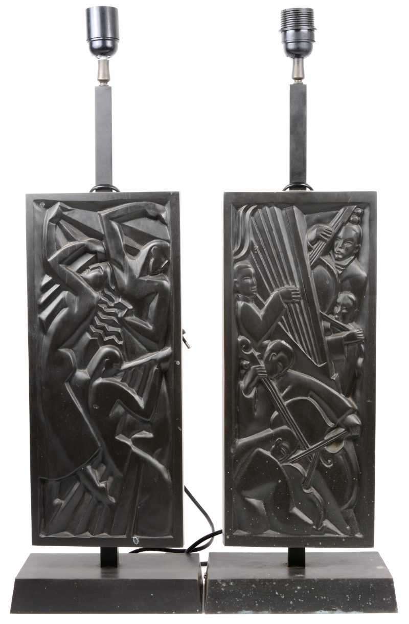 Een paar lampvoeten in de vorm van bronzen plaquettes met een gestileerd reliëfdecor van muzikanten. Zonder kappen.