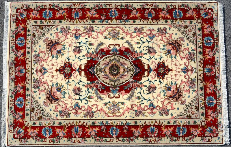 Een handgeknoopt Perzisch karpet van wol en zijde.