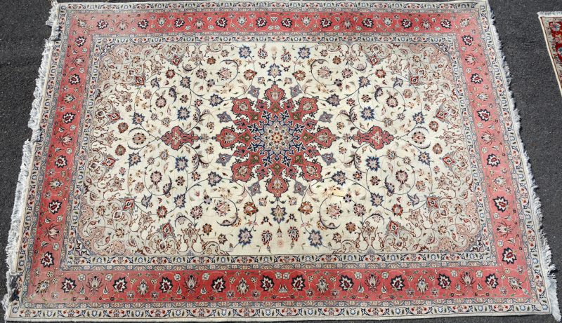 Een handgeknoopt Perzisch wollen tapijt van wol en zijde.