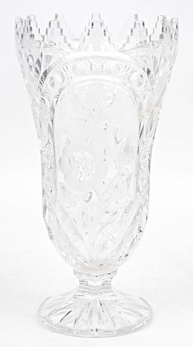 Een vaas van geslepen kleurloosBoheems kristal op voet met een deels gesatineerd decor van bloemen en vlinders.