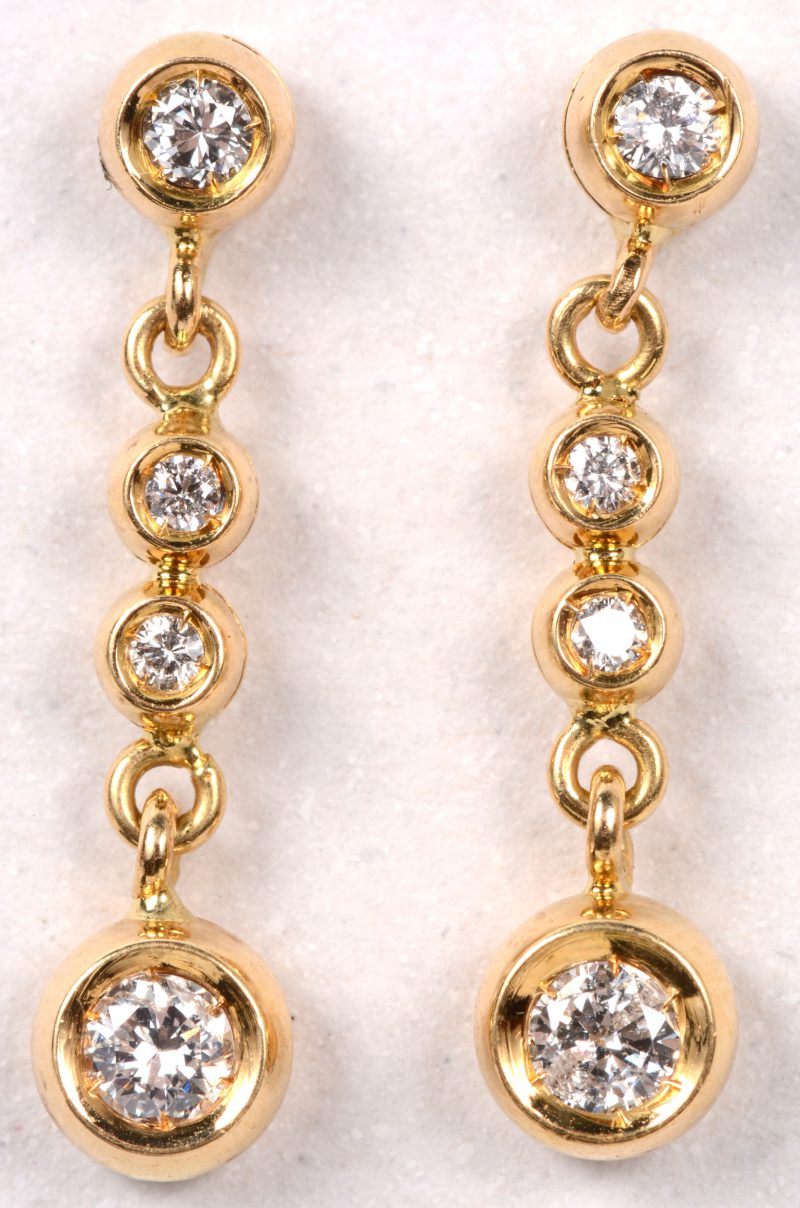 Een paar 18 karaats geel gouden oorbellen bezet met briljanten met een gezamenlijk gewicht van +- 0,80 ct.
