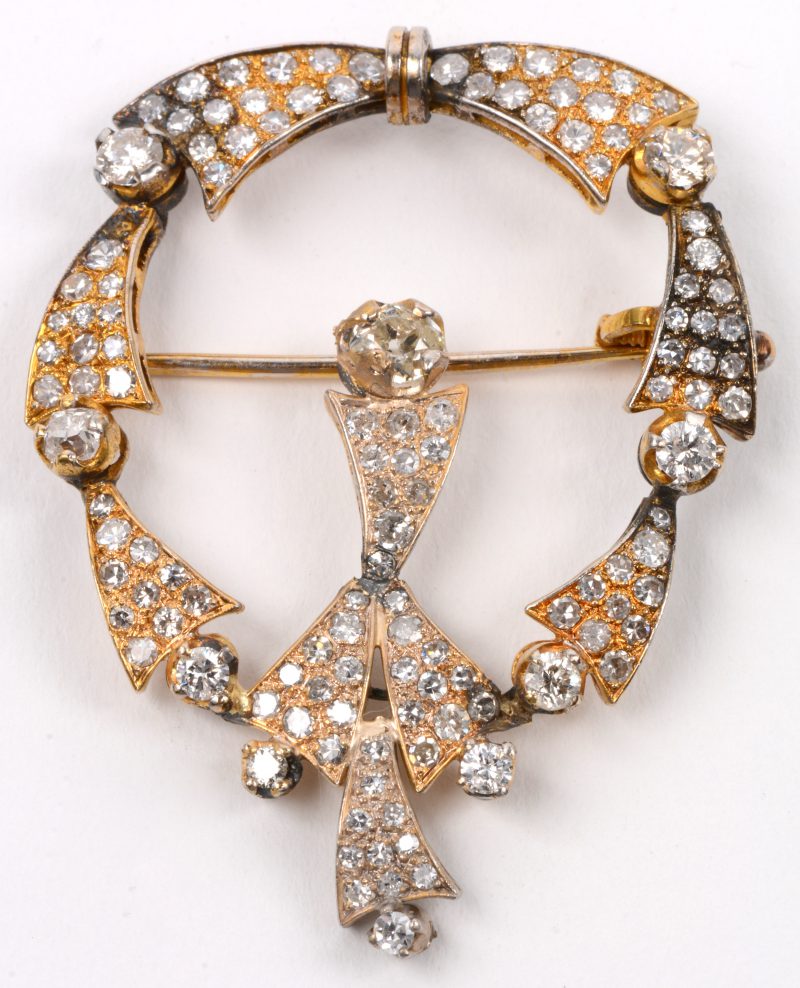 Een 18 karaats wit en geel gouden broche bezet met diamanten met een gezamenlijk gewicht van +- 3 ct.