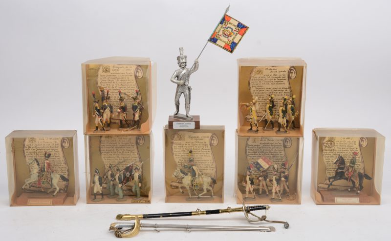 Collectie handgeschilderde tinnen soldaatjes: 16 stuks voetvolk en 3 ruiters. Evenals een wat grotere onbeschilderde vaandeldrager en twee miniatuurzwaarden met schede.