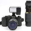 Een analoog fototoestel met Hexonon zoom en met een extra Osawa MG-lens en een flash. In tasje.