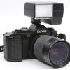 Een analoog fototoestel met Hexonon zoom en met een extra Osawa MG-lens en een flash. In tasje.