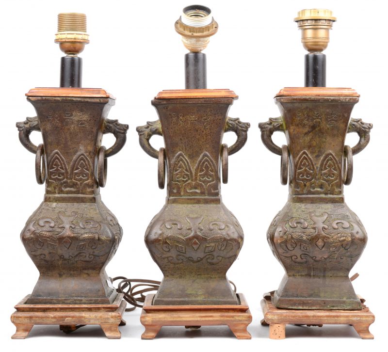 Drie Chinese bronzen siervazen met draakvormige handvatten met ringen. Gemonteerd als lampvoeten.