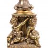 Een messingen lampenvoet in barokke stijl, gedragen door vier putti.