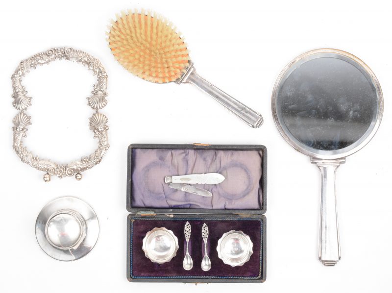 Een lot zilver, bestaande uit een handspiegel en borstel, een fotokader, een peper- en zoutstelletje in etui, een Engelse inktpot en een zakmesje met parelmoeren handvat.