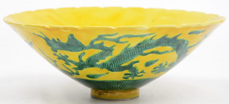 Een kommetje van Chinees porselein met een groen decor van een draak en een feniks op gele fond. Onderaan gemerkt.